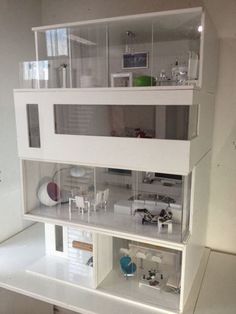 a doll house with all the furniture and accessories in it's white display case