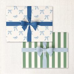 two wrapped gift boxes with blue bows on green and white striped wrapping paper, one is folded in the shape of a bow