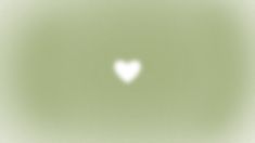 a blurry image of a white heart in the middle of a light green background