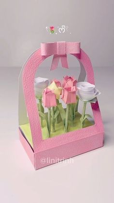 an origami box with pink flowers in it