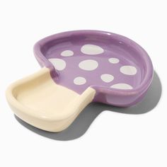 a purple and white polka dot dish with a toothbrush in the bowl on it