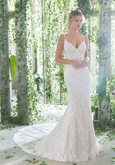 a woman in a white wedding dress standing next to an archway with ivy growing on it