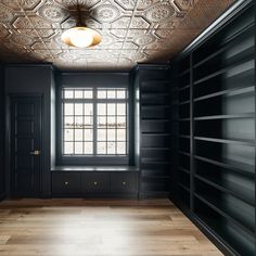 an empty room with black walls and wooden floors