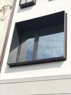 an image of a window that is in the side of a building with sky reflected in it