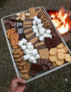 a metal tray filled with marshmallows, crackers and grahamy cookies