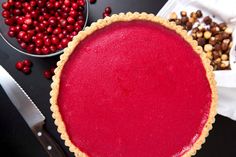 a pie sitting on top of a table with cranberry toppings next to it