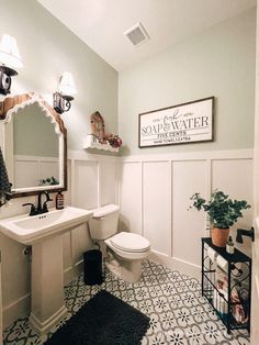 a bathroom with a toilet, sink and mirror in it's center wall area