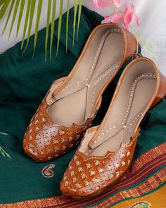 Introducing our "Zendaya" Punjabi jutti, a true epitome of elegance and style meticulously handcrafted by skilled artisans using pure leather. This exquisite footwear features a timeless tan color adorned with unique gold jari work on the stylish upper, creating a mesmerizing blend of tradition and modernity. Each stitch of the "Zendaya" jutti is a testament to the dedication and skill of our artisans, ensuring impeccable quality and attention to detail. The simplicity of its design is complemented by the sweetness of its charm, making it a versatile accessory that effortlessly attracts attention wherever you go. Wearing the "Zendaya" jutti, you'll exude confidence and grace, knowing that you're adorned in a piece of artistry that reflects your unique sense of style. Its understated yet ca Juti Shoes Pattern, Traditional Closed Toe Wedding Sandals, Formal Flats For Festivals With Round Toe, Traditional Brown Closed Toe Sandals, Festive Cutdana Sandals For Festivals, Brown Open Toe Sandals For Wedding, Traditional Festive Sandals With Single Toe Strap, Traditional Sandals With Single Toe Strap For Festive Occasions, Traditional Open Toe Leather Shoes With Leather Sole