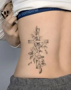 a woman with a cross tattoo on her lower back and the bottom part of her stomach