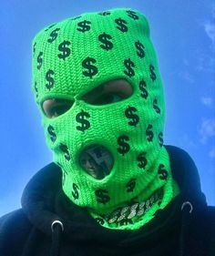 a person wearing a green mask with dollar signs on it's face and the sky in the background