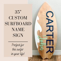 a wooden surfboard with the words caper painted on it next to a sign