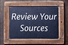 a blackboard with the words review your sources written on it