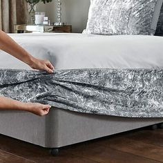 a woman is unwrapped from her mattress on the floor in front of a bed