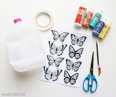 the supplies needed to make butterfly stencils are displayed next to scissors, glue, and water bottle