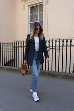 Emma Hill wears navy linen blazer, mid wash straight leg jeans, white tennis socks, New Balance 530 trainers, tan loewe puzzle bag, white vest. Casual Spring Summer outfit Navy Blazer Outfits, Emma Hill, 90’s Outfits, Trainers Outfit, Blazer Outfit, Blazer Jeans, Neue Outfits