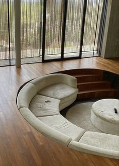 a living room with wooden floors and large windows