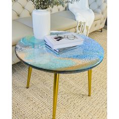 a table with a book on it in front of a white couch and some flowers