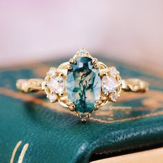 Celebrate your love story with the enchanting Esme Moss Agate Engagement Ring. Expertly crafted from 14K Solid Yellow Gold, this ring showcases an exquisite oval-cut moss agate, embodying timeless elegance and exceptional brilliance.►The design draws inspiration from fairy-core vintage aesthetics, making it a perfect piece for those who appreciate the charm of yesteryear combined with modern sophistication. The intricate detailing and romantic allure of the Esme ring make it an ideal choice for