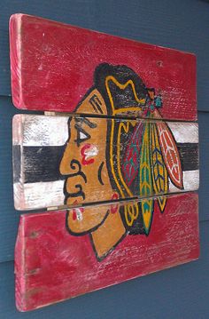 a wooden sign with the chicago black hawks painted on it's face and stripes