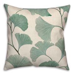 a green and white pillow with leaves on it