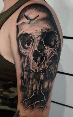 a man's arm with a black and grey tattoo on it, featuring a skull