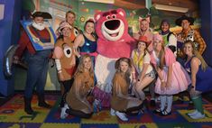 a group of people in costumes posing for a photo with the characters from sesame street