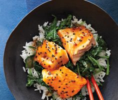 salmon and rice in a black bowl with chopsticks