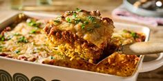 a casserole dish with meat and cheese being lifted from the casserole