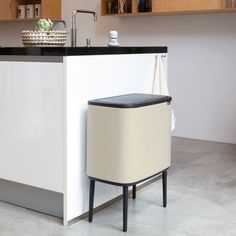 a white kitchen with black counter tops and wooden cabinets in the background, along with a dishwasher on an island