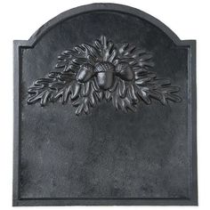 a metal wall plaque with an acorn and leaves design on it's face