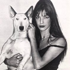 a black and white photo of a woman holding a dog