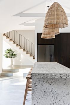 a kitchen with an island and stairs in the background