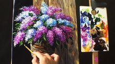 someone is painting flowers in a basket on the easel