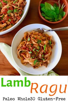 a plate of pasta with meat and sauce on it next to a bowl of basil