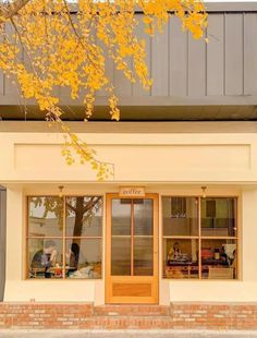 a store front with yellow leaves on the tree