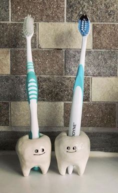 two toothbrushes sitting next to each other on a counter