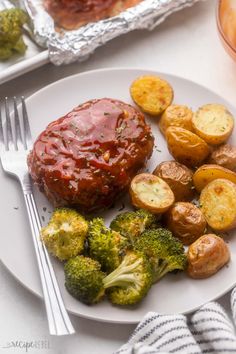 a white plate topped with meat covered in sauce next to potatoes and broccoli