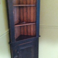 an old wooden bookcase in the corner of a room