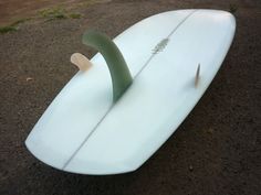 a white surfboard laying on the ground