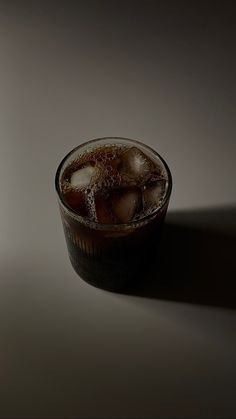 a glass filled with ice sitting on top of a table