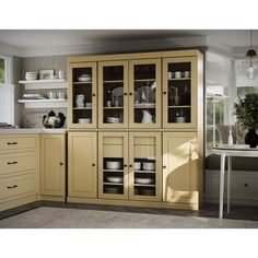 a kitchen with yellow cabinets and white counter tops in front of a dining room table