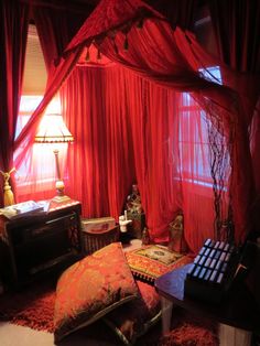 a living room with red curtains and furniture