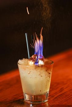 a small glass filled with something on top of a wooden table