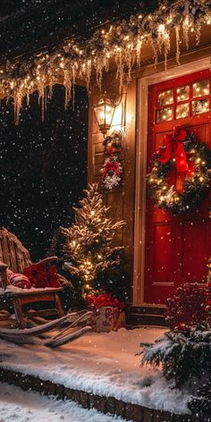 a red front door decorated with christmas wreaths and lights