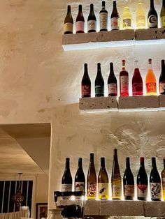 bottles of wine are lined up on the wall