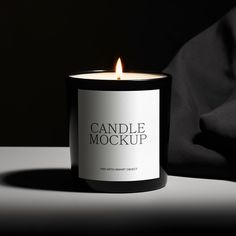 a candle that is sitting on top of a table next to a black shirt and pillow