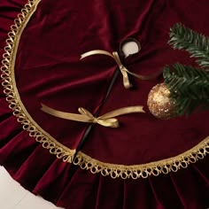 a red table cloth with gold trim and a christmas ornament