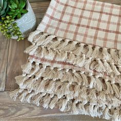 a close up of a blanket on a wooden floor with succulents and a potted plant