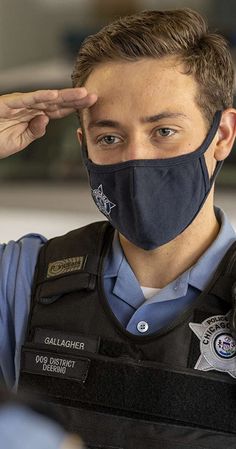 a police officer adjusts his face mask