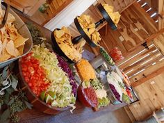 many different types of food are arranged on a buffet table, including chips and salads